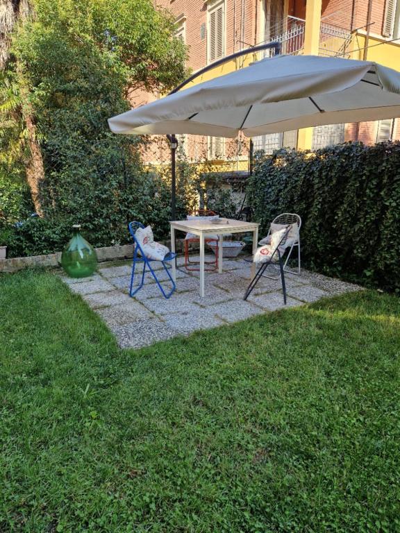 einen Tisch, zwei Stühle und einen Regenschirm in einem Hof in der Unterkunft Minimal Chic House in Bologna