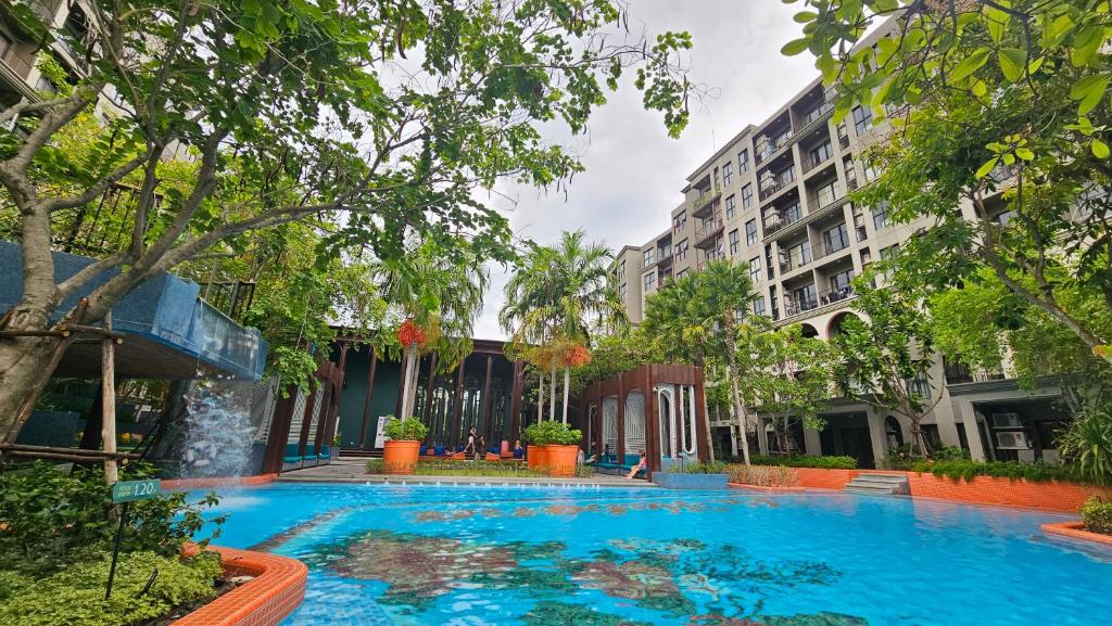 a large blue swimming pool with trees and buildings at La Habana HuaHin by ABCD in Hua Hin