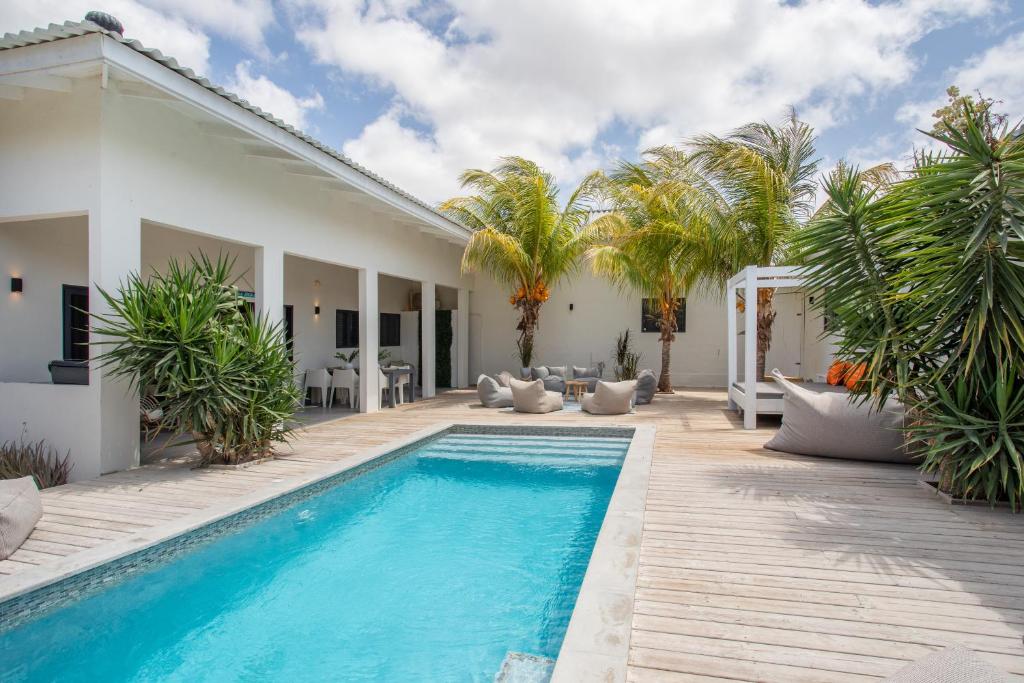 una piscina en el patio trasero de una casa con palmeras en Villa Zarza en Jan Thiel