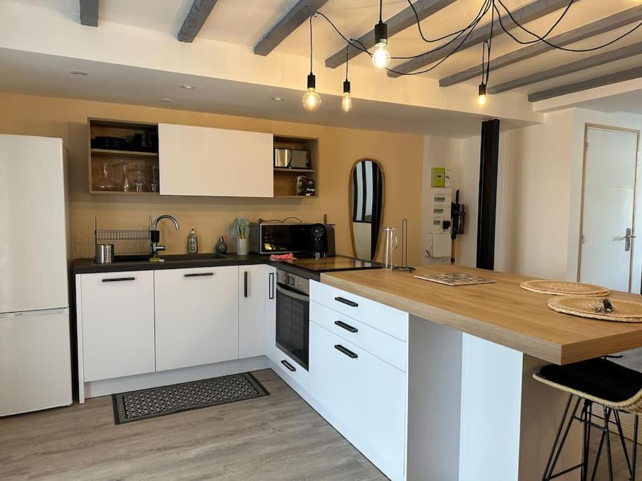 une cuisine avec des armoires blanches et un comptoir en bois dans l'établissement Appartement moderne avec jardin et parking, à Vannes