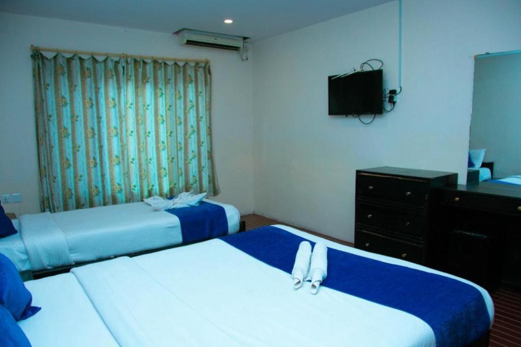 een hotelkamer met 2 bedden en een televisie bij Taj Residency Pokhara in Pokhara