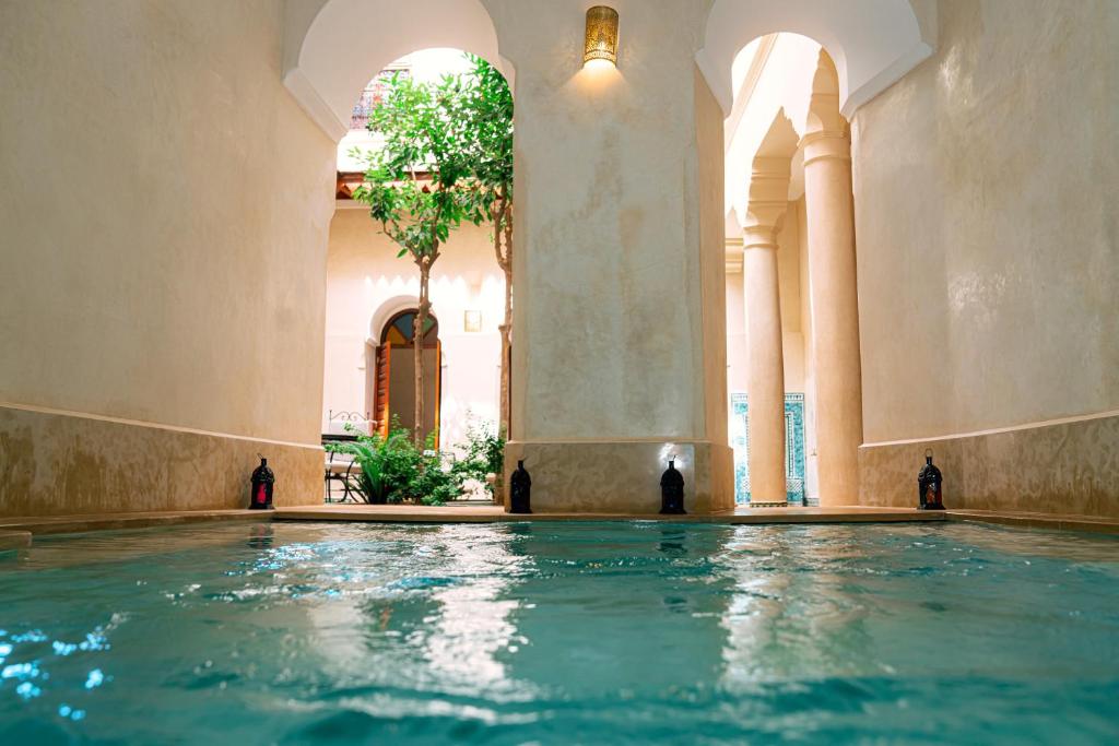 a swimming pool in a building with a tree at Riad Dar Zaouia in Marrakech