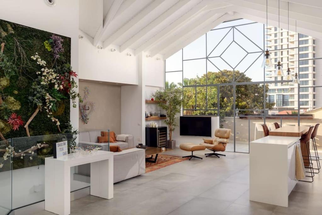 een woonkamer met witte meubels en een groot raam bij Stunning 4BR Duplex Penthouse by HolyGuest in Tel Aviv