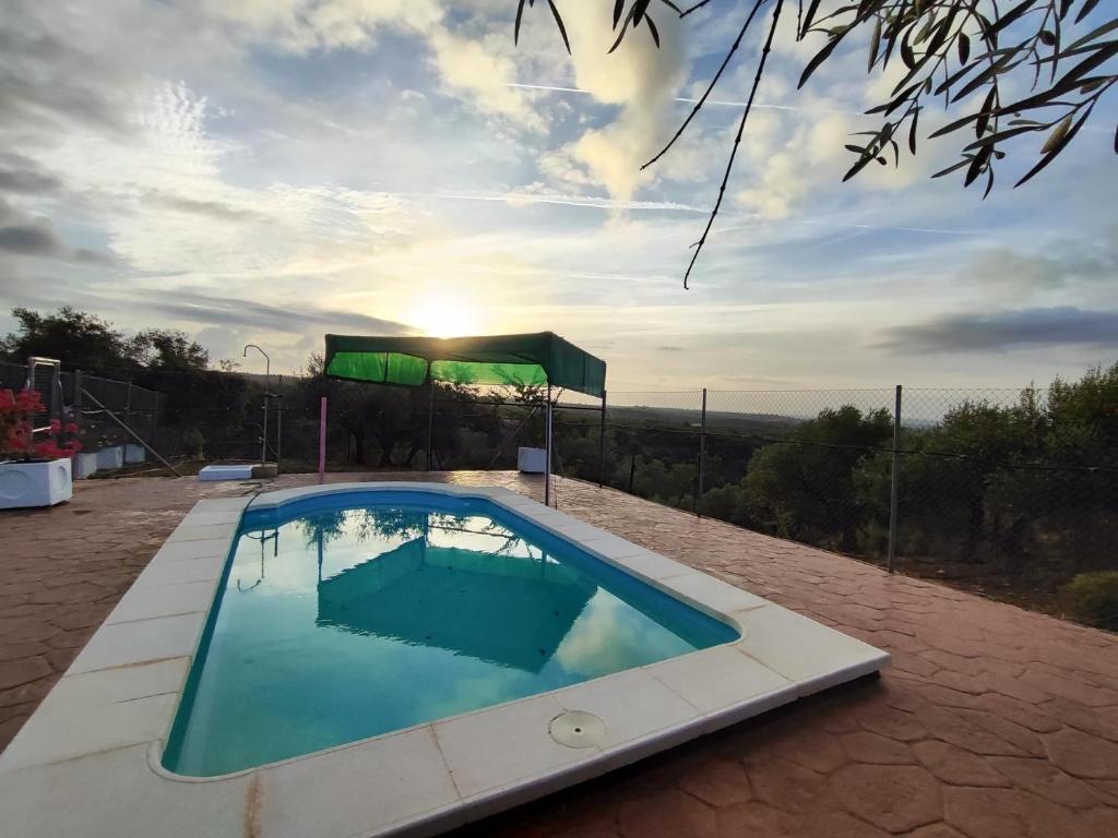 uma piscina com sol ao fundo em Casa Rural Mesa Del Lobo Cabrahigo em Sevilha