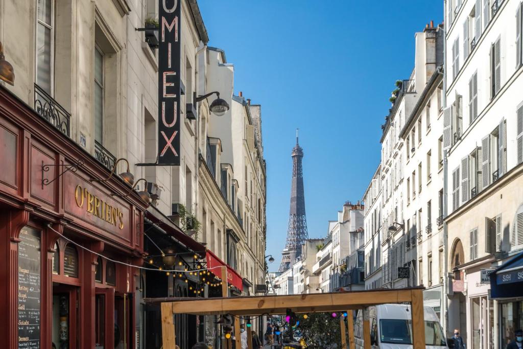 a city street with a view of the eiffel tower at Happy Stay Paris - Cosy Studios - 5 min to Eiffel Tower in Paris