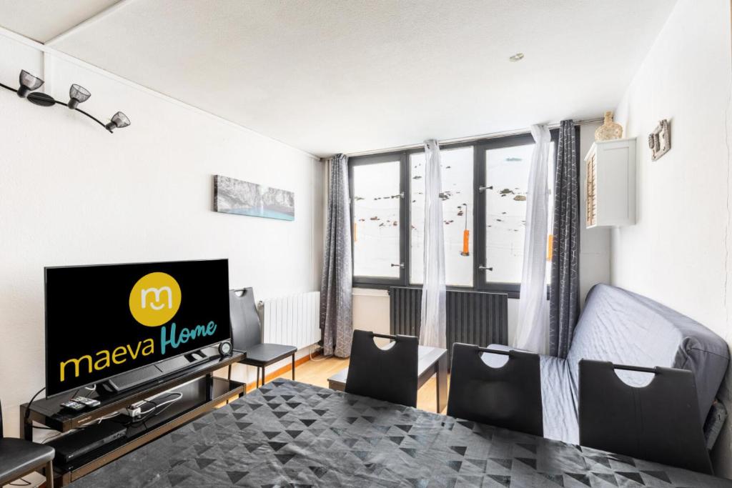 un salon avec une télévision, une table et des chaises dans l'établissement Résidence Le Tourmalet - maeva Home - Appartement 3 pièces 9 personnes - Sélection MAE-3804, à La Mongie