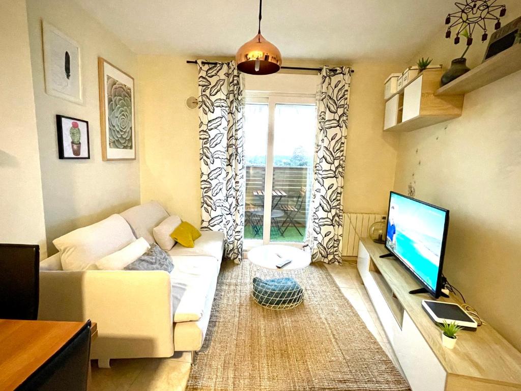a living room with a couch and a flat screen tv at Apartamento a 50 m de Playa-Jardín. Boiro in Boiro