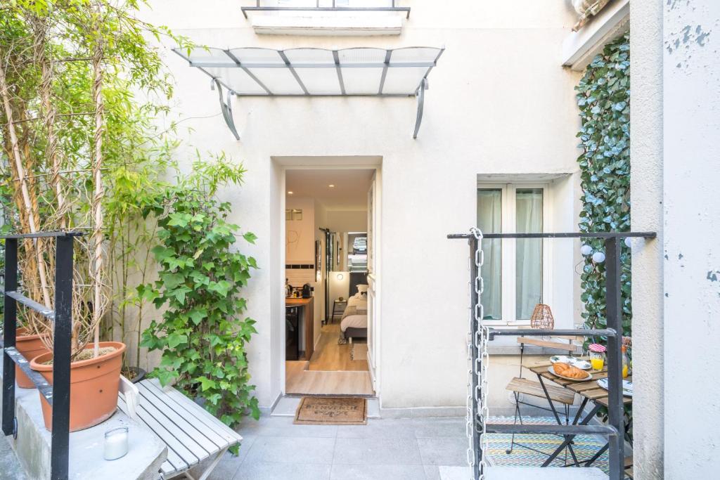 a white house with a porch with a bench at Studio Terrasse Privée 5 min to Eiffel Tower in Paris