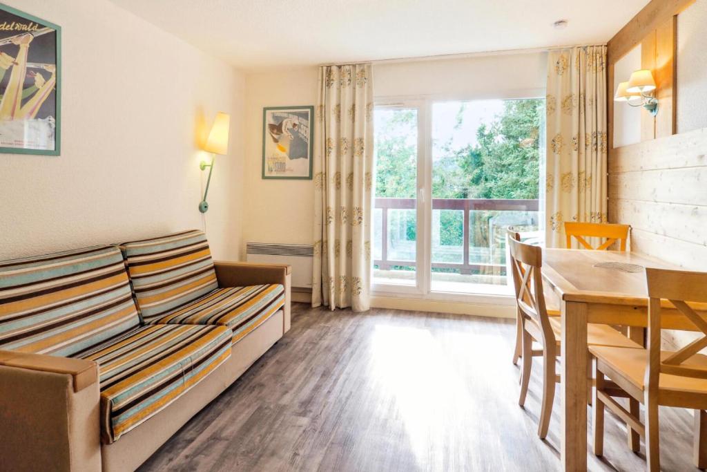 un salon avec un canapé et une table dans l'établissement Résidence Le Pédrou - maeva Home - Studio 4 Personnes Confort MAE-6969, à Font-Romeu-Odeillo-Via