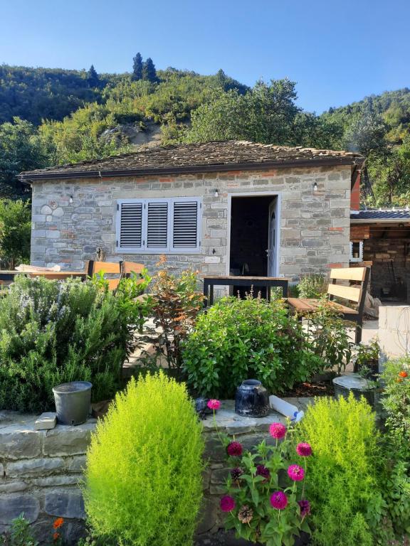ein Steinhaus mit Garten davor in der Unterkunft Bujtina Lugina e vjosës in Përmet