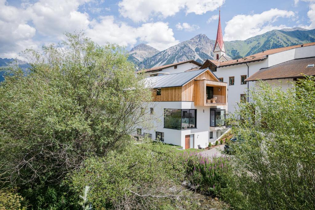 a large white building with a church with a steeple at Chalet Ortles M in San Valentino alla Muta