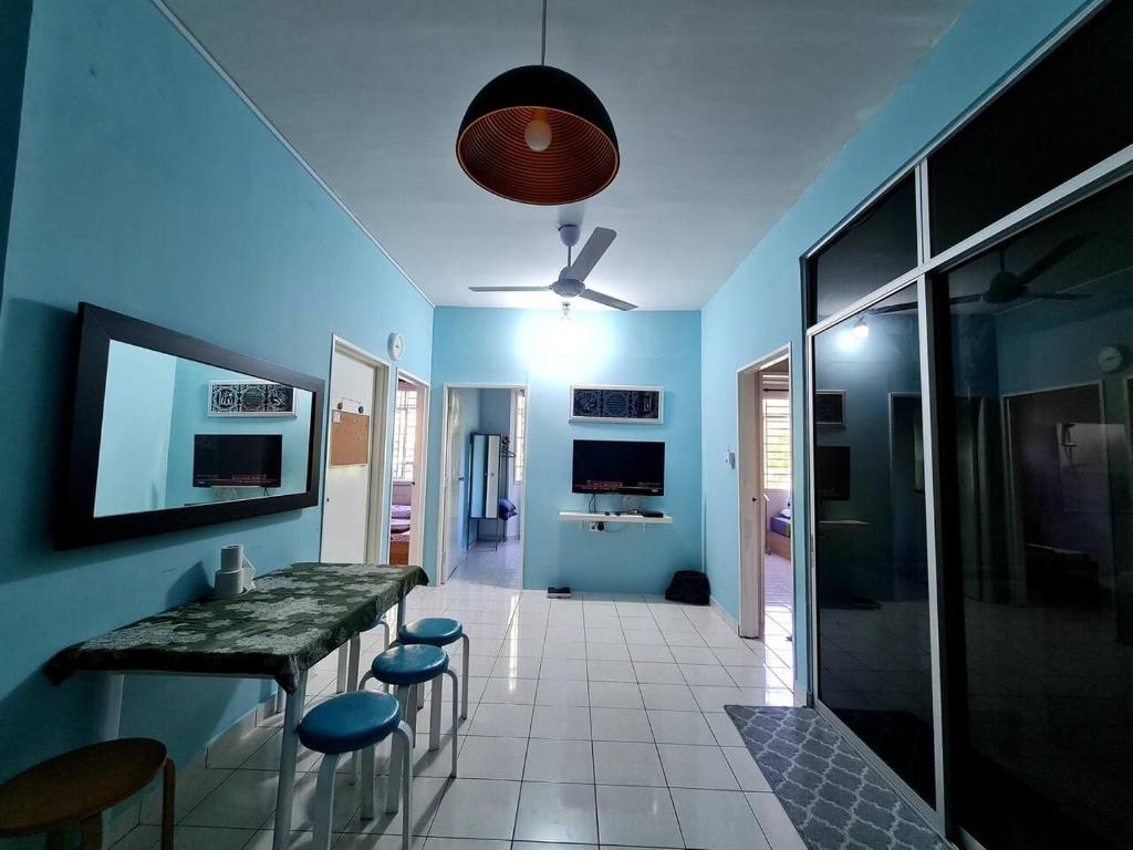Cette chambre bleue comprend une table et des tabourets. dans l'établissement Edaman Guest House, à Kota Kinabalu