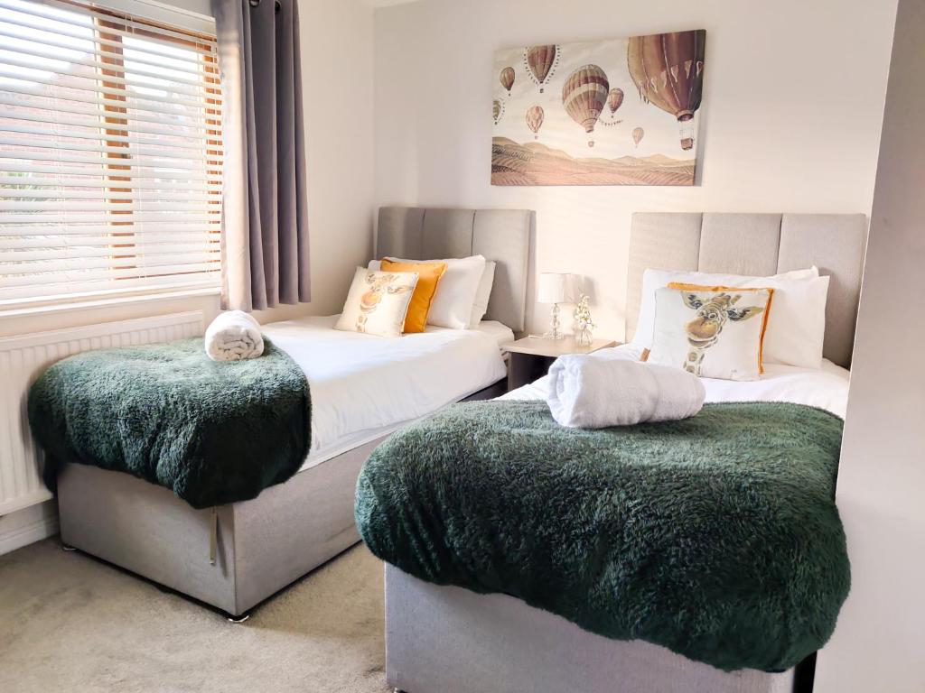 um quarto com 2 camas e cobertores verdes em Dean House, 2 BR, Sleeps 5,Kitchen, FREE Parking, Spacious, Garden, Close Motorways em Doncaster