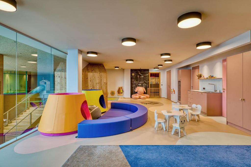 a childrens play room with a play table and chairs at Falkensteiner Family Hotel Montafon - The Leading Hotels of the World in Schruns-Tschagguns