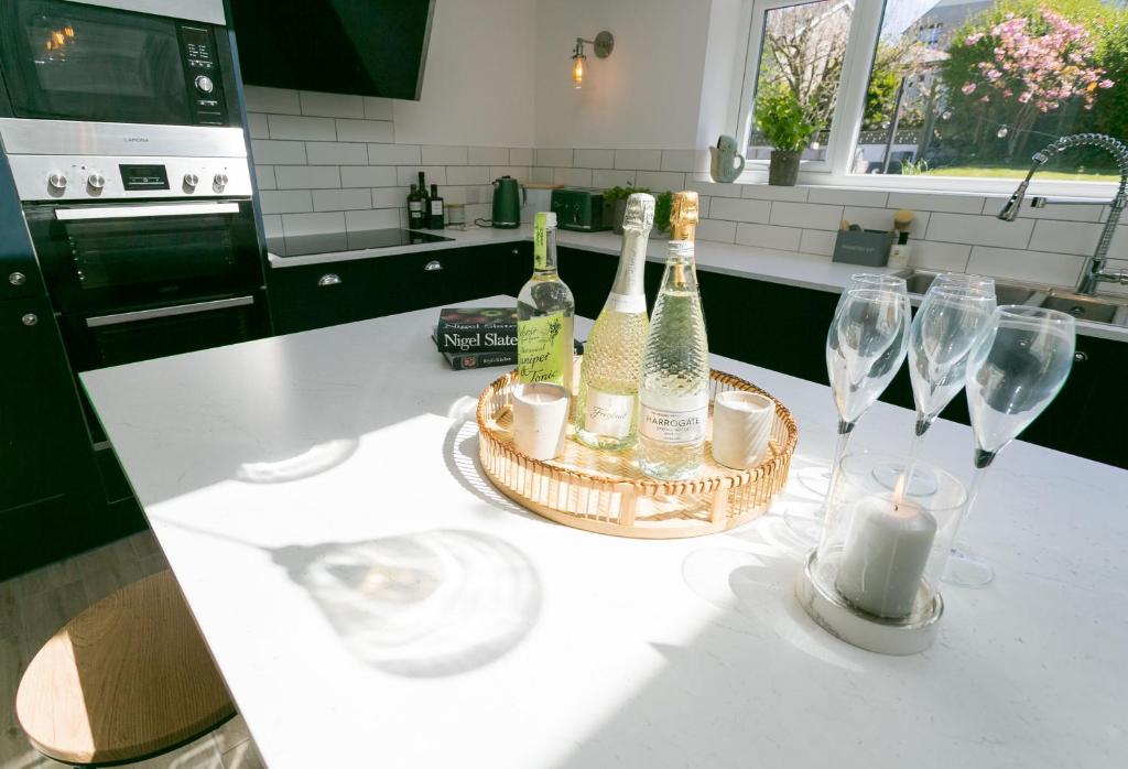a group of wine bottles and glasses on a kitchen counter at Treforris in Rhosneigr