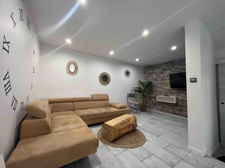 Una sala de estar con un sofá y un televisor. en Les Suites du Palais, en Carcassonne