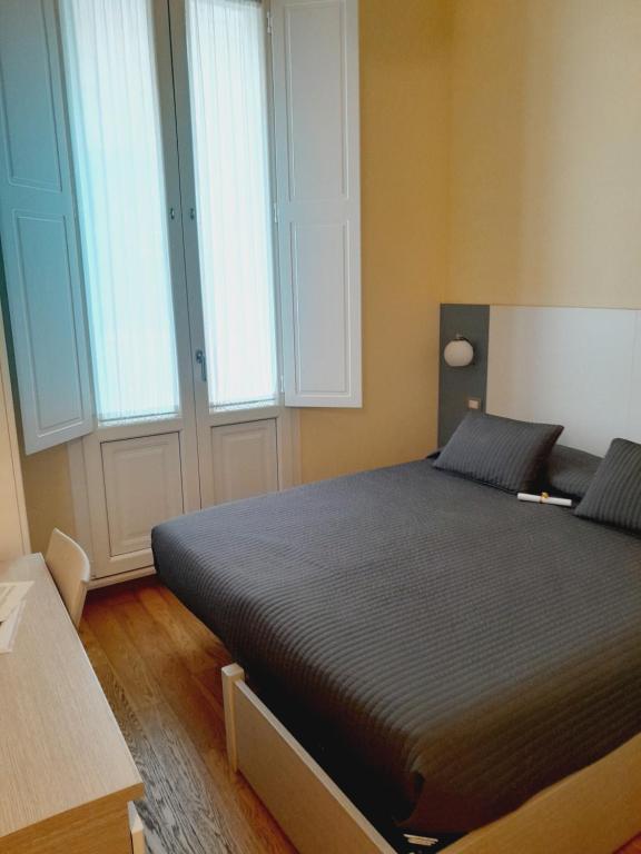 a bed in a room with two windows at Terra di Puglia in Mola di Bari