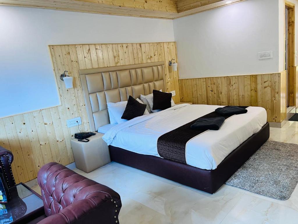 1 dormitorio con 1 cama grande y 1 sofá de cuero en Aadarsh Hotel, Nanital, en Nainital