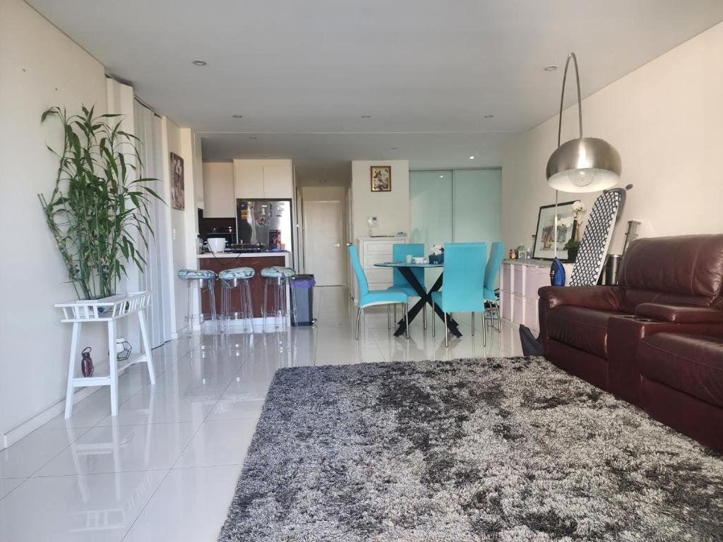 a living room with a couch and a table at Parramatta Shared Apartment in Sydney