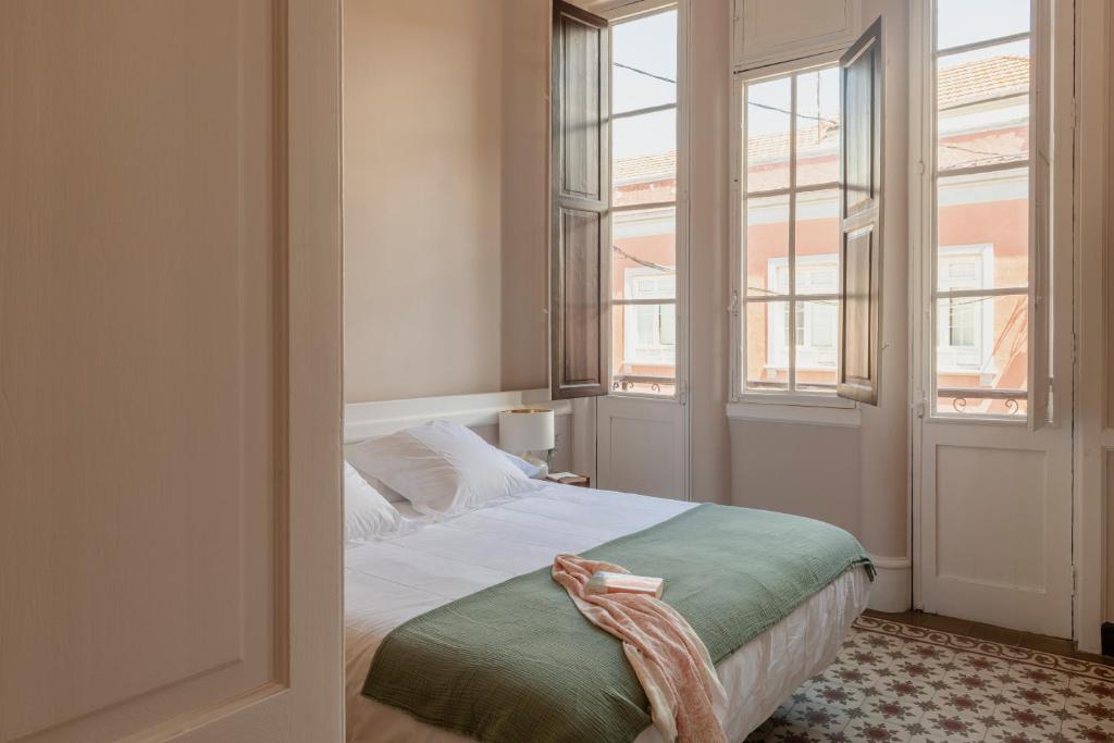 a bedroom with a bed and two windows at El Ombú del Agua in La Laguna