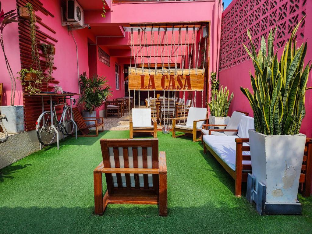 馬普托的住宿－La Casa Moz，餐厅拥有粉红色的墙壁,配有椅子和植物