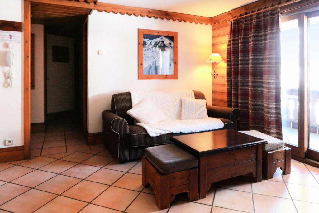 ein Wohnzimmer mit einem Sofa und einem Couchtisch in der Unterkunft Résidence La Ginabelle - maeva Home - 4 Pièces 6 Personnes Sélection 71 in Chamonix-Mont-Blanc