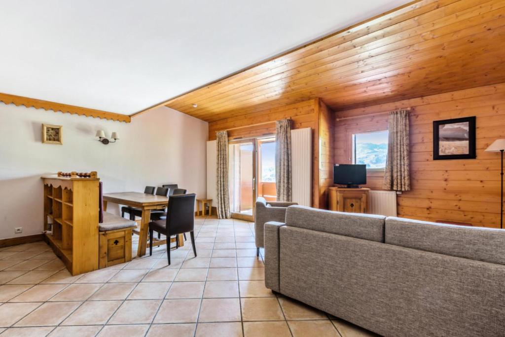 un salon avec une table et des chaises dans l'établissement Résidence Les Hauts Bois - maeva Home - Appartement 4 pièces 8 personnes Selection MAE-2806, à Aime La Plagne