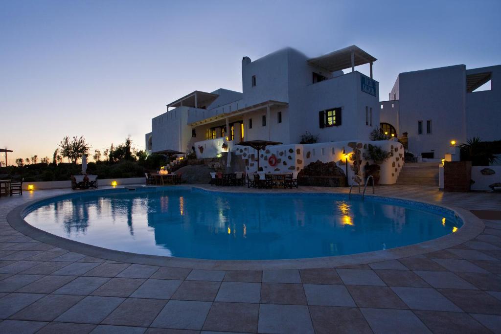 une grande piscine en face d'un bâtiment dans l'établissement Naxos Kalimera Apartments, à Agia Anna