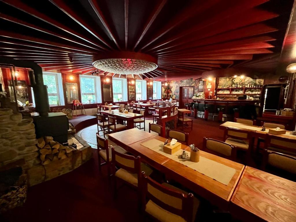 restauracja ze stołami i krzesłami oraz bar w obiekcie Penzion & Restaurant Pod Čerťákem w mieście Harrachov