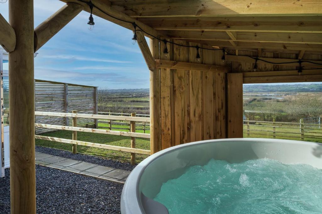 a bath tub with a view of a barn at Willow Cottage in Gaerwen