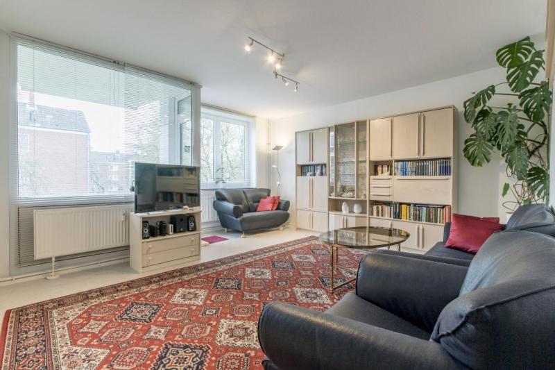sala de estar con 2 sofás y TV en Private Rooms en Hannover