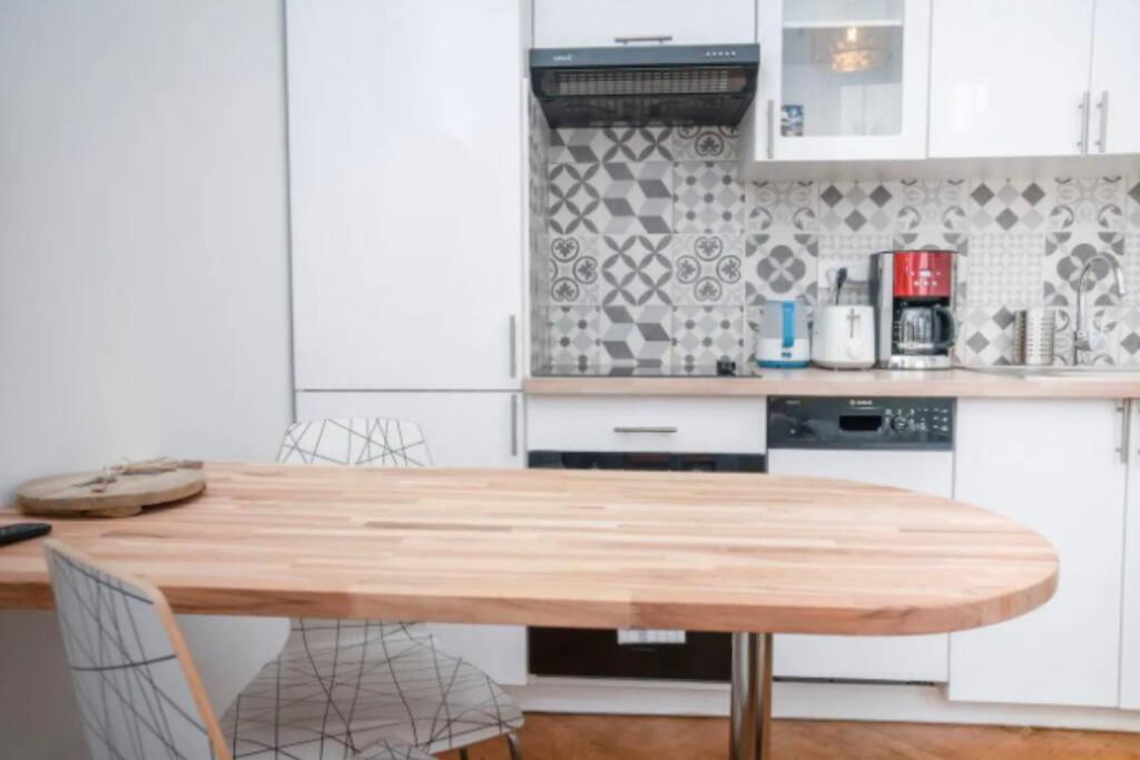 une cuisine avec une table et des chaises en bois dans l'établissement Charmant 3 pièces en plein centre-ville, à Nice