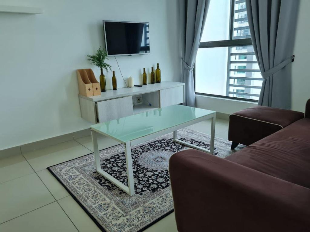 a living room with a glass table and a tv at Tulip Homestay by AK Group in Cyberjaya