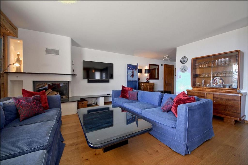 een woonkamer met twee blauwe banken en een open haard bij Tayannes 016 in Verbier