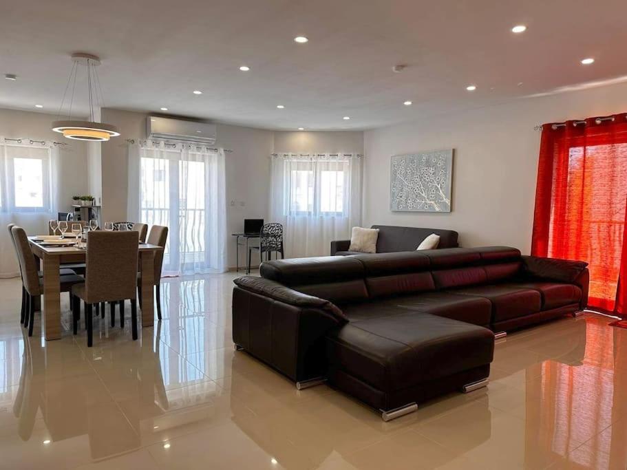 sala de estar con sofá y comedor en Cozy, Spacious 3 Bedroom Maisonette, 6 to 9 ppl, 1 min walk from Seafront en Marsaxlokk