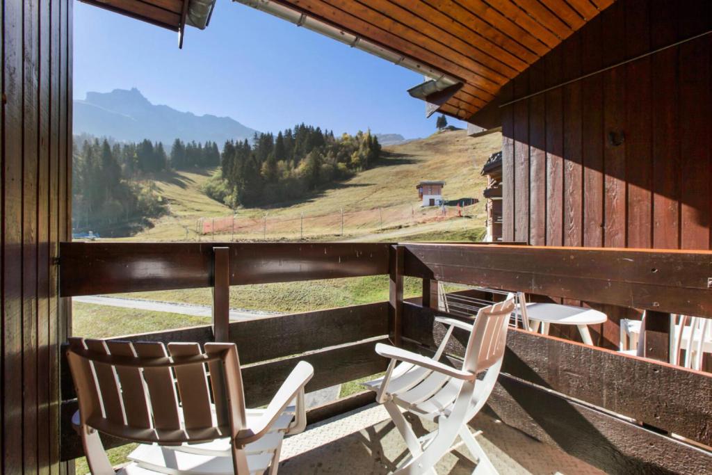 a balcony with two chairs and a view of a mountain at Quartier Crève Cœur - maeva Home - Appartement 2 pièces 4 personnes 21 in Valmorel