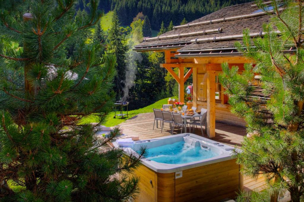 a hot tub on a deck next to a gazebo at Chalet Hollygotty - OVO Network in La Clusaz