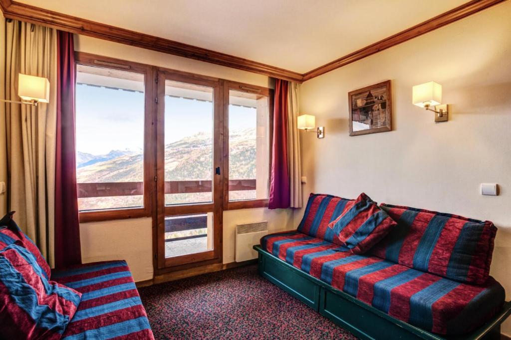 un salon avec un canapé et une fenêtre dans l'établissement Résidence La Marelle et Le Rami - maeva Home - Appartement 2 pièces 5 personnes Selection MAE-2243, à La Plagne Tarentaise