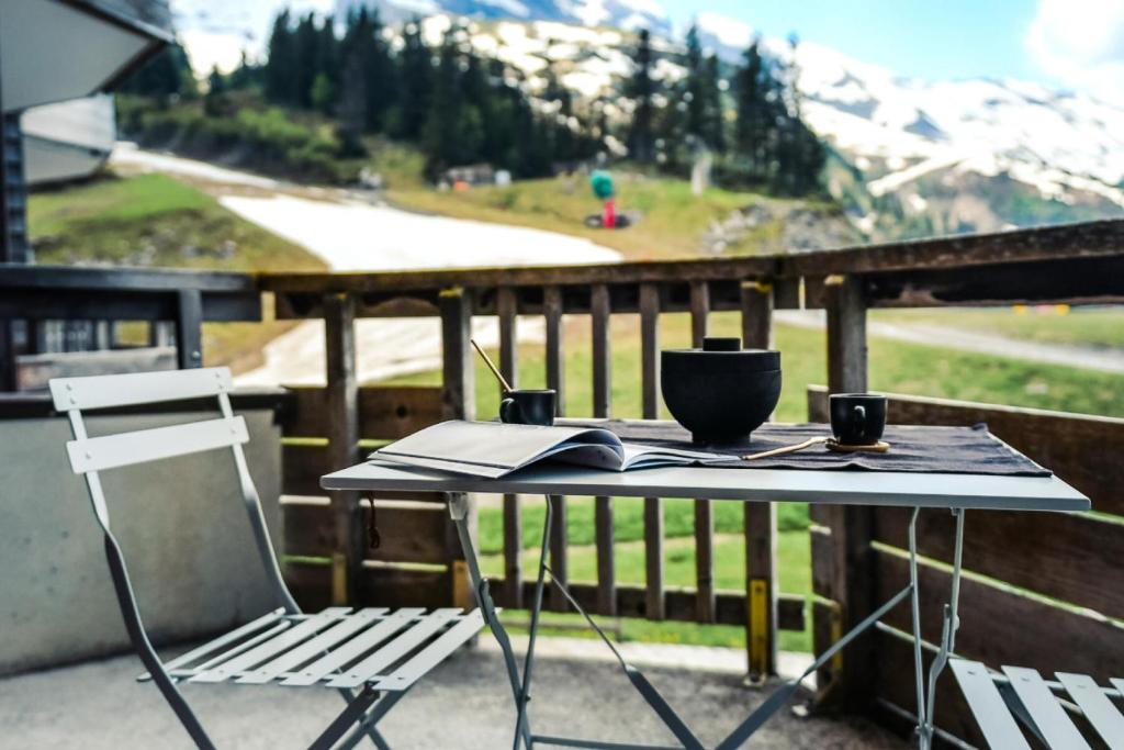 d'une table et d'une chaise sur un balcon avec une montagne. dans l'établissement Résidence Sépia - maeva Home - Appartement 2 pièces 5 personnes Sélection MAE-4319, à Morzine