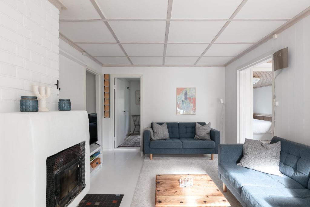 - un salon avec un canapé et une cheminée dans l'établissement Family Holiday Home in Ingarö, à Enkärret