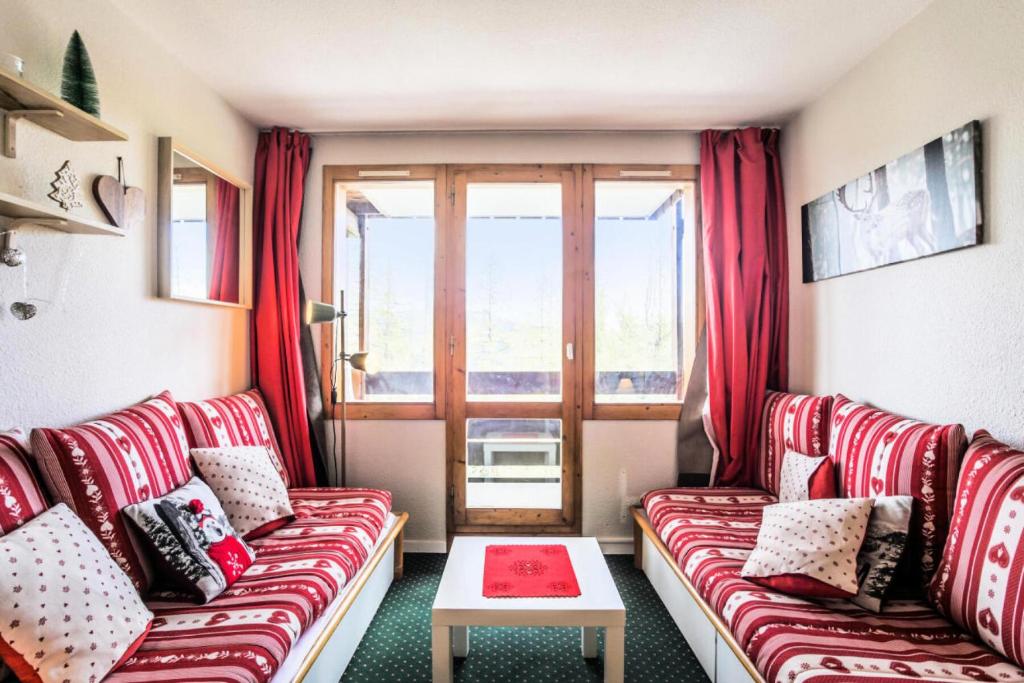 - un salon avec des canapés rouges et une fenêtre dans l'établissement Résidence Le Hameau du Sauget - maeva Home - Appartement 2 pièces 4 personnes Confort MAE-5604, à La Plagne Tarentaise