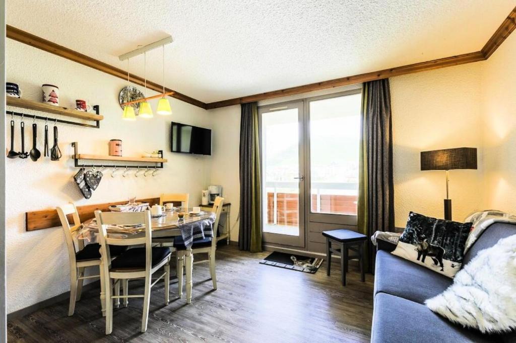 a dining room and living room with a table and a couch at Résidence Les Bergers - maeva Home - Studio 4 personnes - Sélection MAE-6894 in LʼHuez