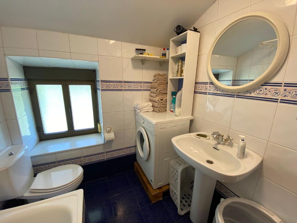 een badkamer met een wastafel en een wasmachine bij La Casita de Coya 