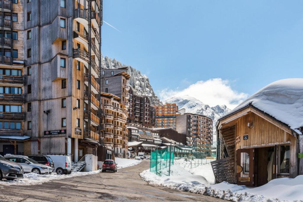 une rue enneigée dans une ville avec des bâtiments dans l'établissement Résidence Les Alpages - maeva Home - Studio 1 pièce 4 personnes Sélection MAE-9982, à Morzine