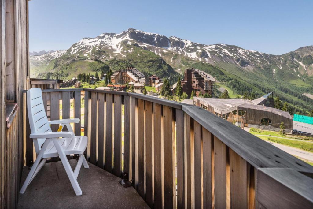 une chaise blanche assise sur un balcon avec une montagne dans l'établissement Résidence Les Fontaines Blanches - maeva Home - Appartement 2 pièces 5 personnes Confort MAE-2329, à Morzine