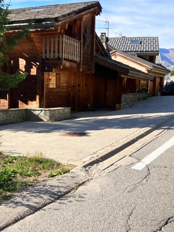 an empty street in front of a wooden building at Chalet Le Lauzet in Les Deux Alpes