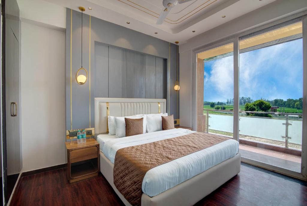 um quarto com uma cama grande e uma janela grande em Comfort Inn Karnal em Tirāwari