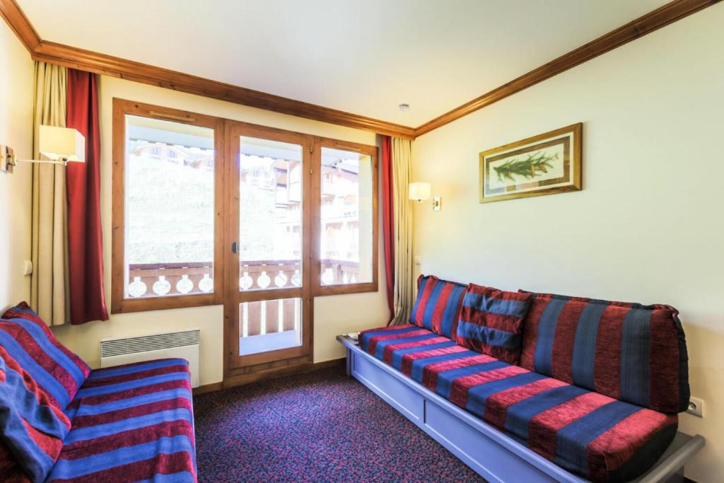 un salon avec un canapé et une fenêtre dans l'établissement Résidence La Marelle et Le Rami - maeva Home - Appartement 2 pièces 5 personnes Sélection MAE-6258, à La Plagne Tarentaise