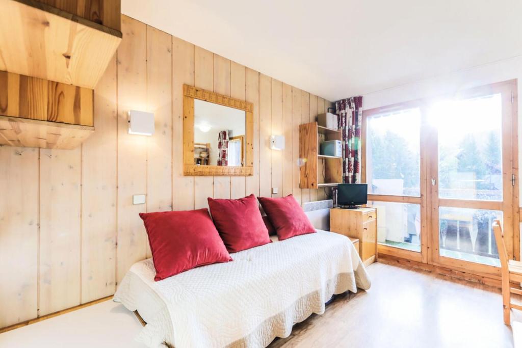 - une chambre avec un lit doté d'oreillers rouges dans l'établissement Résidence Les Brigues - maeva Home - Appartement 2 pièces 6 personnes Confort MAE-7008, à Courchevel