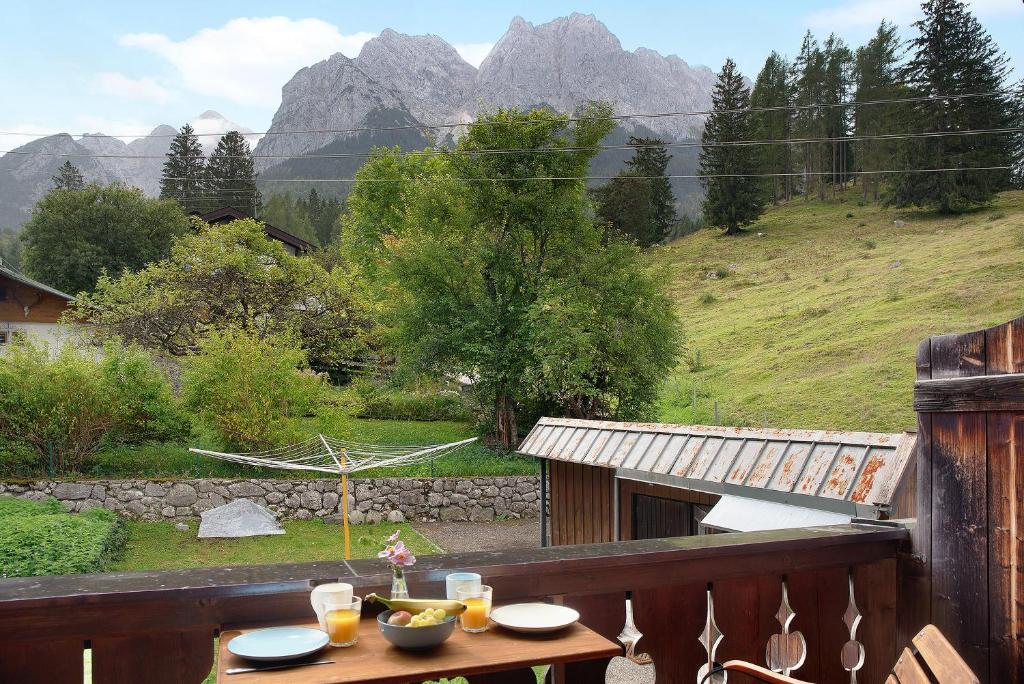 una mesa en un balcón con vistas a las montañas en Ferienwohnung Alpspitznest, en Grainau